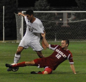 .T. Kotowski (12) battles for a ball in an exhibition game against Notre Dame in 2014. He tore his ACL two games later. Photo via Scout Archives.