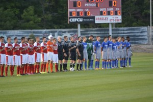 Players on the Bradley soccer team place their hand over their heart while the national anthem plays before their season opener. Photo by Adam Rubinberg.