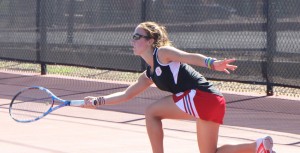 Sophomore Aimee Manfredo reaches for a return during a match. Photo by Ann Schnabel.