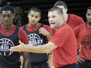 Basketball head coach Brian Wardle (right) talks to sophomore Donte Thomas (left) and freshman Dwayne Lautier-Ogunleye (center). Photo by Chris Kwiecinski.