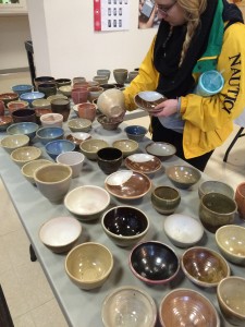 A student browses through ceramic bowls sold by Bradley’s Pottery Club at its sale Wednesday in Heuser Art Gallery. Photo by Maddie Gehling.