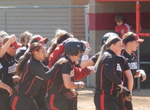 Erika Hansen (center) gets mobbed by her teammates after hitting a walk- off RBI double to win the series against Evansville. Photo by Chris Kwiecinski.