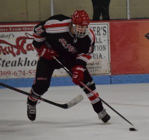 Sophomore Cole Harris skates through his opponents zone, looking for a lane to take a shot on net. Photo by Shelby Caruso.