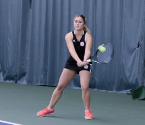 ￼Junior Alejandra de Lasa hits a back-hand return in a home match earlier this season. photo by Justin Limoges