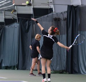 Junior Aimee Manfredo lifts the ball in the air in preparation for a serve in a match earlier this winter. photo by Justin Limoges