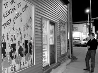 A pedestrian looks at the new community murals at a store front at Main Street and Sheridan Road. The murals are aimed to improve the look of the Main Street corridor. The Walkable West Bluff campaign organized the painting of the murals. Photo by Adam Moulton