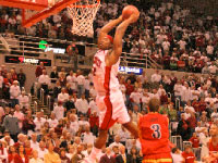Senior Theron Wilson soars through the air to slam the ball in last Friday’s contest against UIC. Wilson finished with a double-double. Photo by Louis Anberg