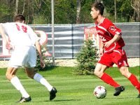 Sophomore Christian Meza looks for an open teammate down field and tries to avoid a Louisville opponent at Shea Stadium against Louisville in the Danny Dahlquist Memorial Game. The Cardinals defeated the Braves 3-1. Photo by Megan Loos